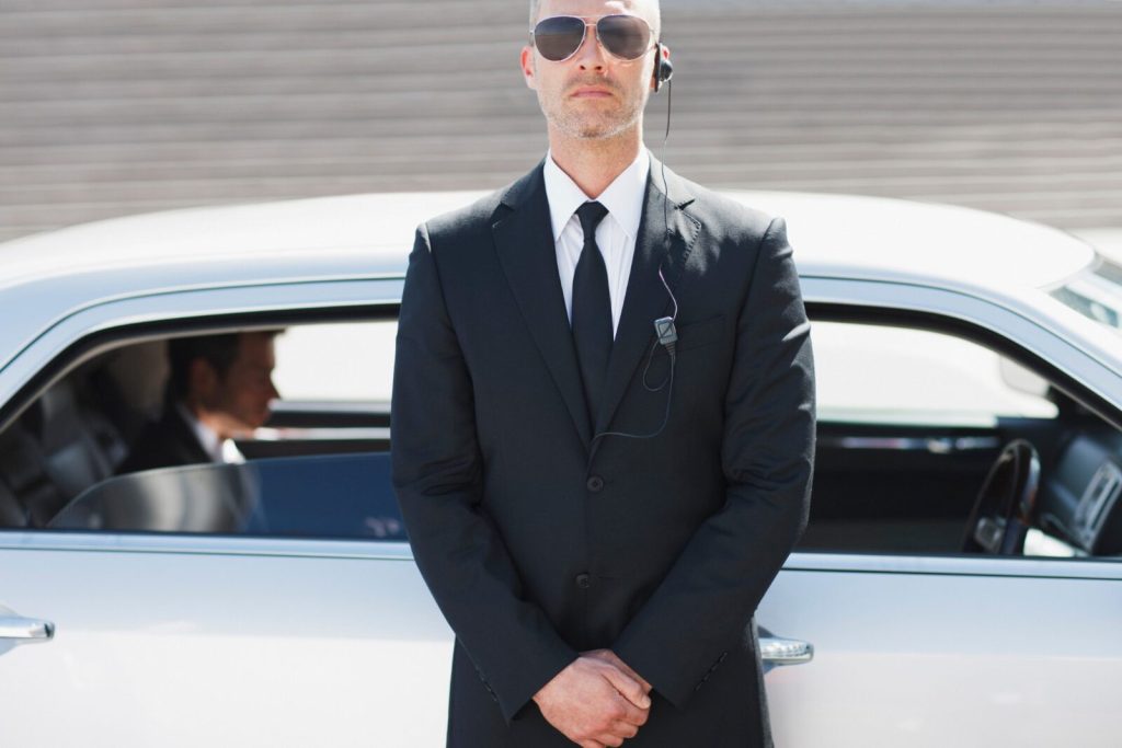 Unarmed security guard standing by car